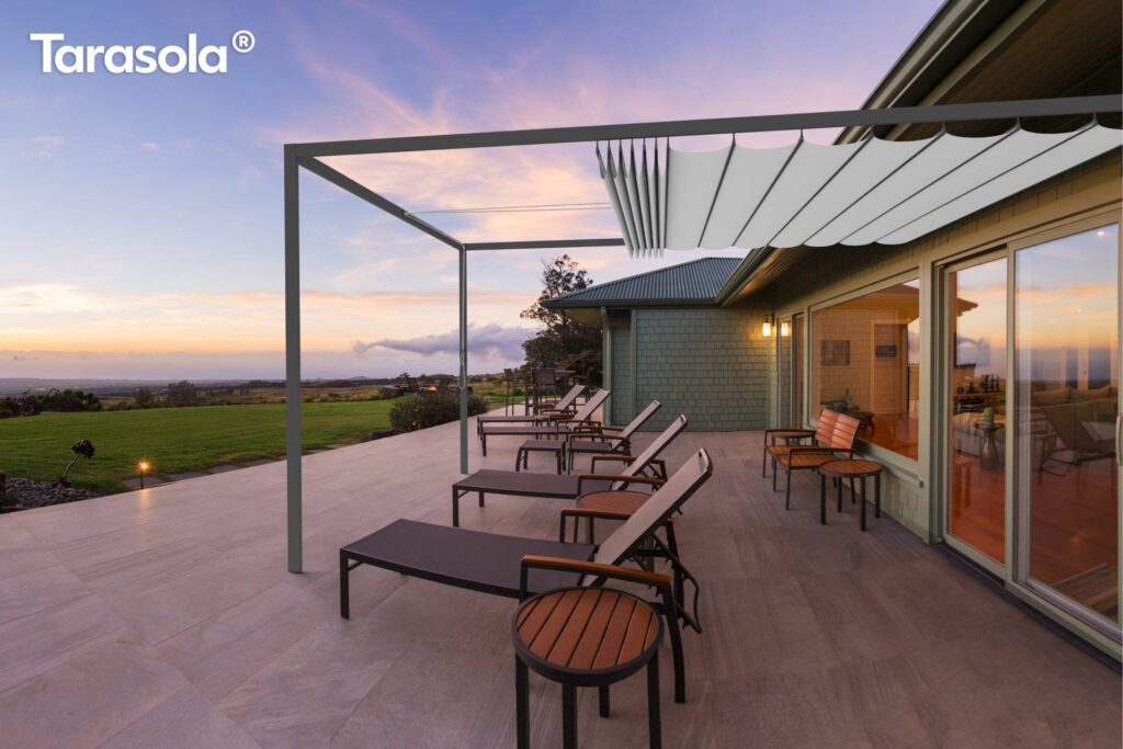 Bild zeigt die Wave-Pergola von Sankika Pergolas auf einer Holzterrasse bei Sonnenuntergang.
